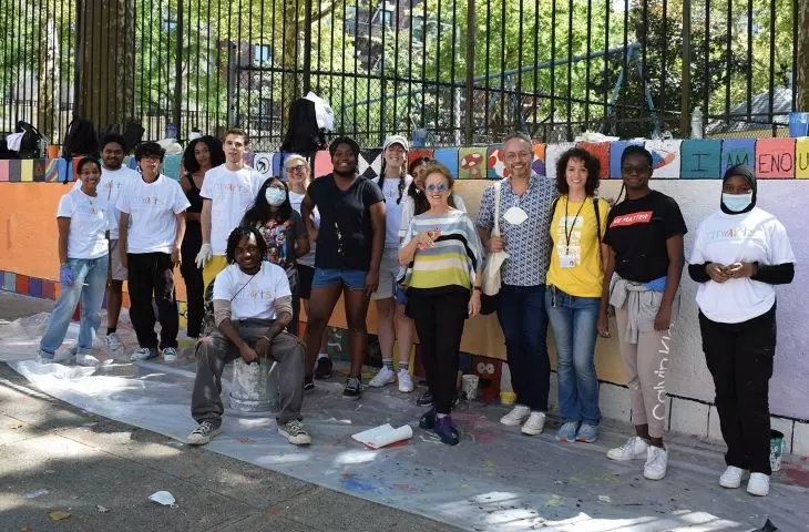 Volunteers, children participating in the painting of Peace Walls and Tsipi Ben-Haim in the background of two New York walls realized by CITYarts