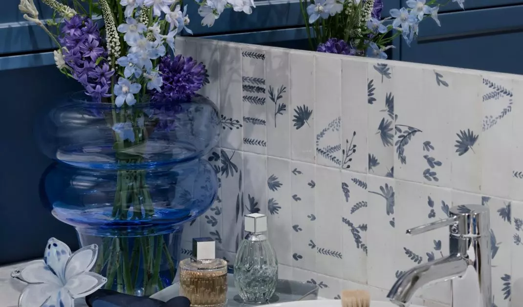 The area above the washbasin has been tiled with a floral pattern 