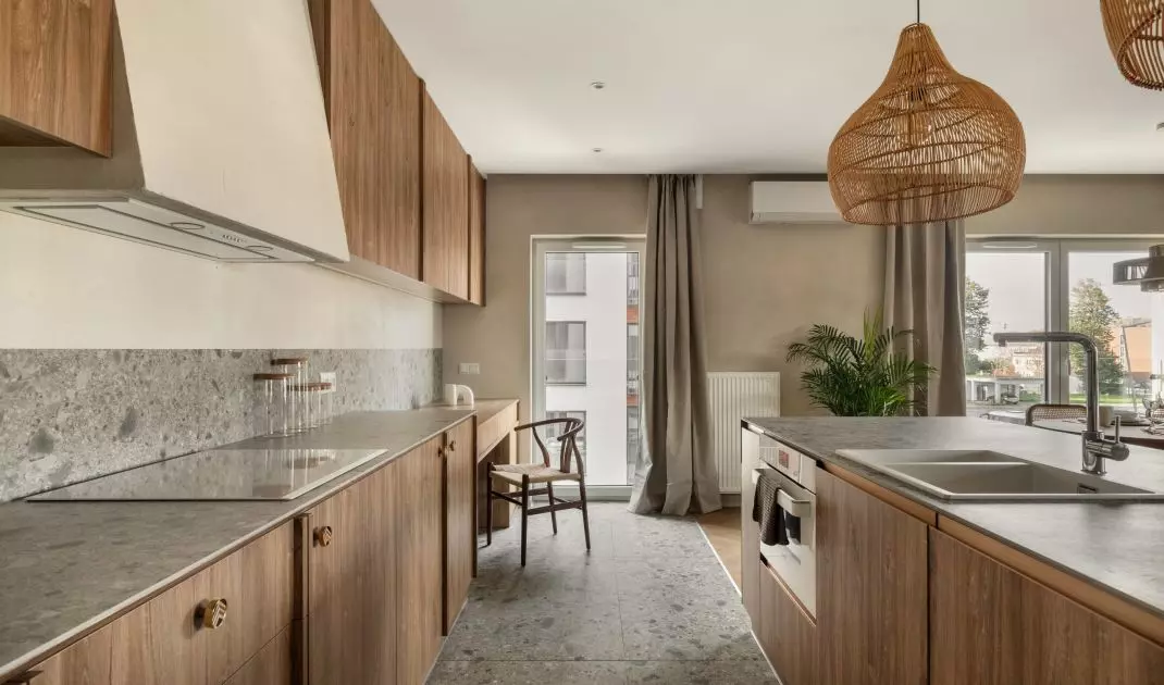 The arrangement combines light colors, warm woods, plaids and tiles with a terrazzo motif