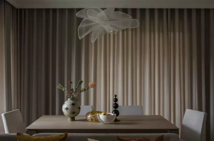 A large table and upholstered chairs create a dining area