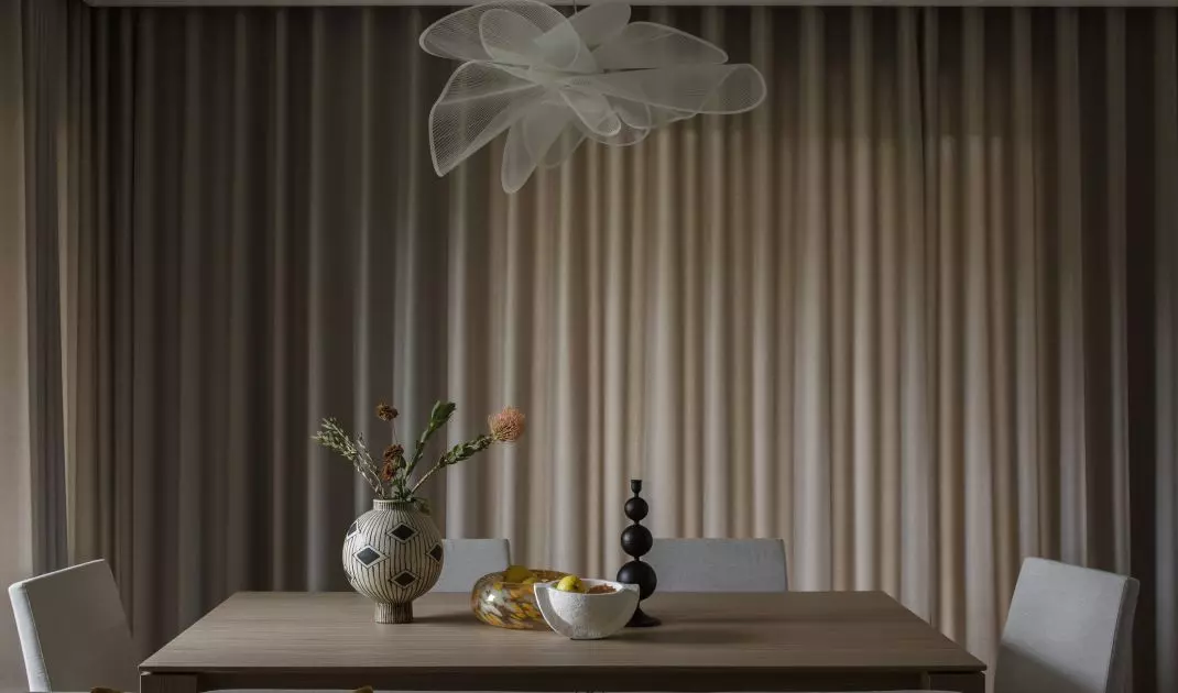 A large table and upholstered chairs create a dining area