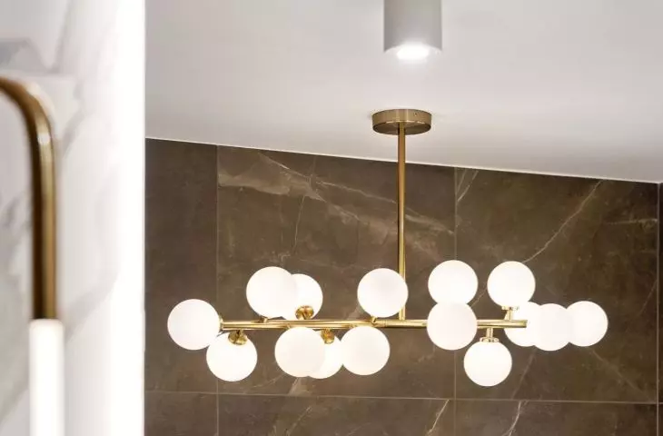A decorative lamp hangs over the bathtub