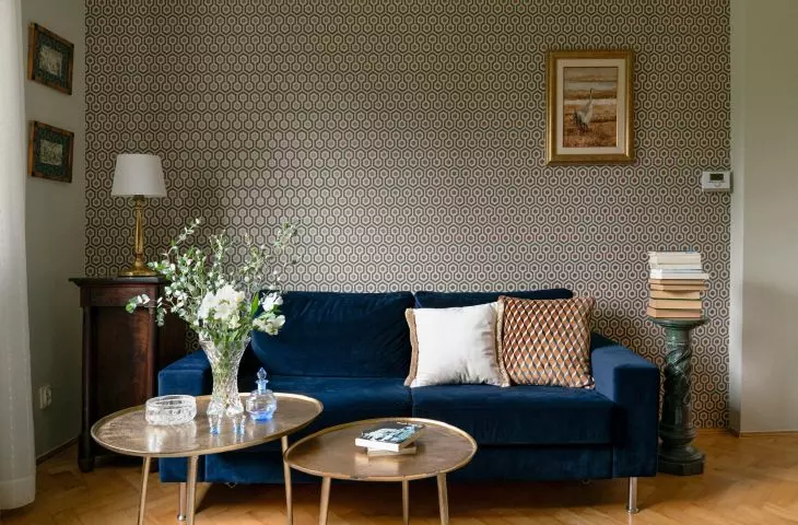 Wallpaper adorning the wall behind the sofa has a slight sheen