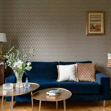Wallpaper adorning the wall behind the sofa has a slight sheen