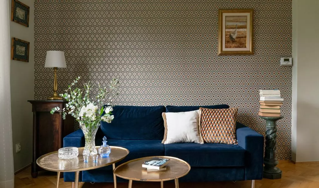Wallpaper adorning the wall behind the sofa has a slight sheen