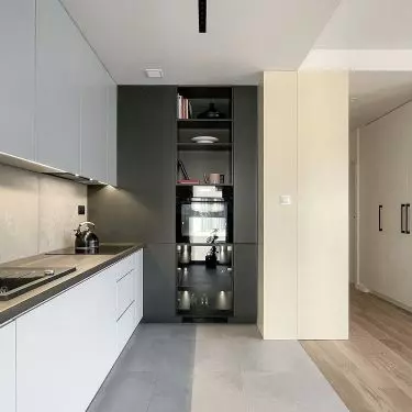 In the kitchenette, the architects used a combination of white and dark gray
