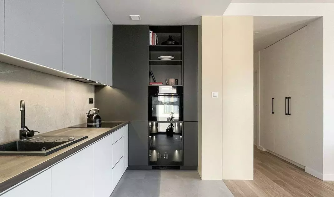 In the kitchenette, the architects used a combination of white and dark gray