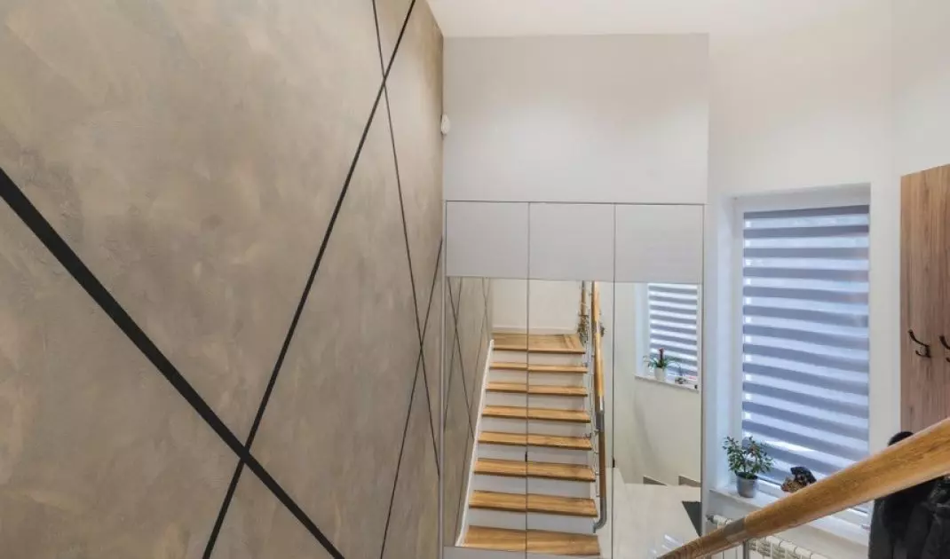 At the confluence of the stairs is a closet with mirrored fronts