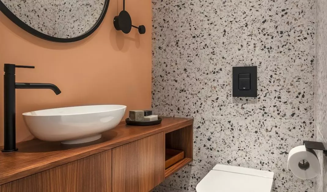 W łazience dla gości architekci zastosowali modny odcień brzoskwini