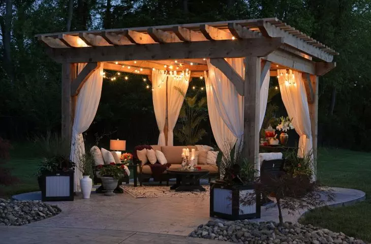 Romantyczna pergola w ogrodzie? Jeśli wybierzesz drewno i zwiewne zasłony, bez trudu uzyskasz ten efekt