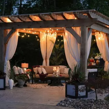 A romantic pergola in the garden? If you choose wood and airy curtains, you can easily achieve this effect