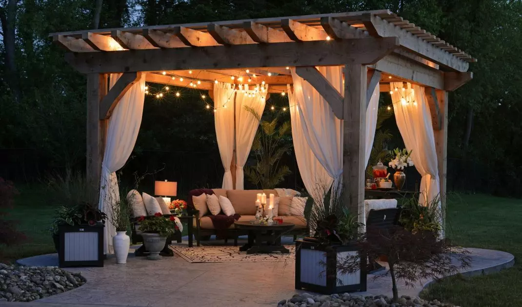 Romantyczna pergola w ogrodzie? Jeśli wybierzesz drewno i zwiewne zasłony, bez trudu uzyskasz ten efekt