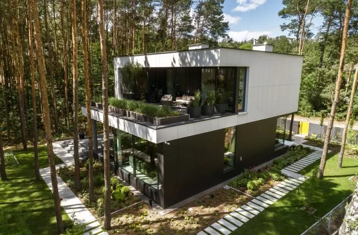 The house is surrounded by a pine forest