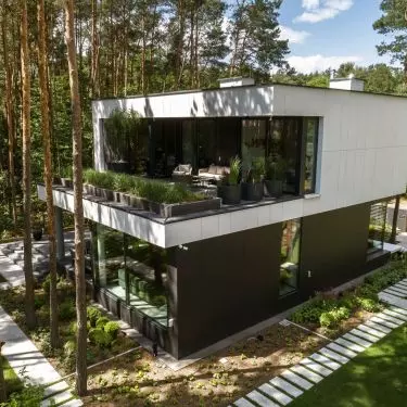 The house is surrounded by a pine forest