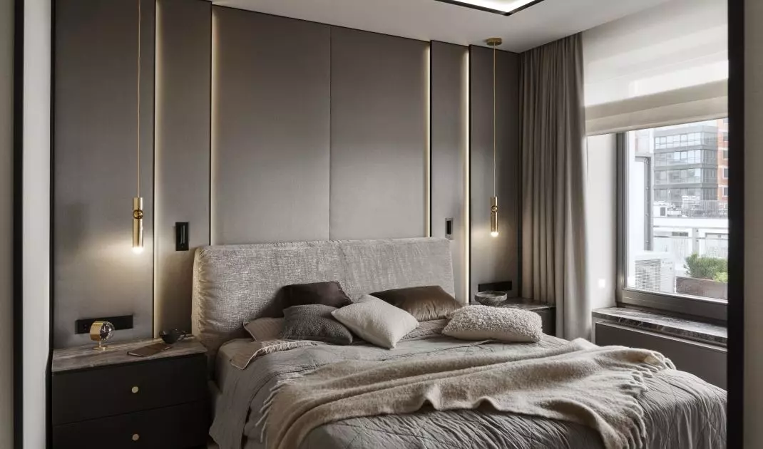 The wall behind the bed was lined with upholstered panels