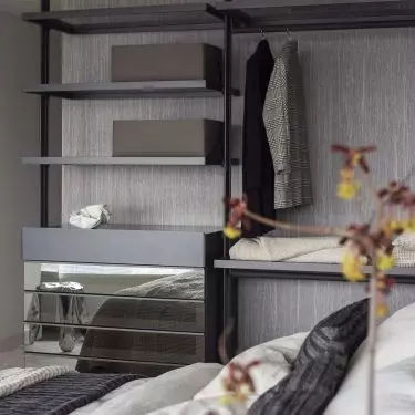 Open closet and mirrored fronts optically enlarge the bedroom