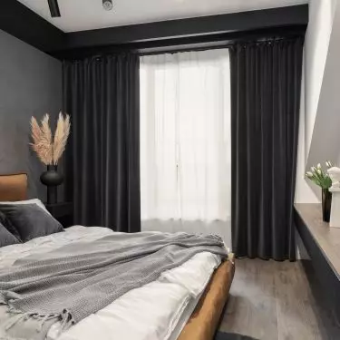 The bedroom is located in the attic. So the architect used thick dark curtains to protect from harsh light