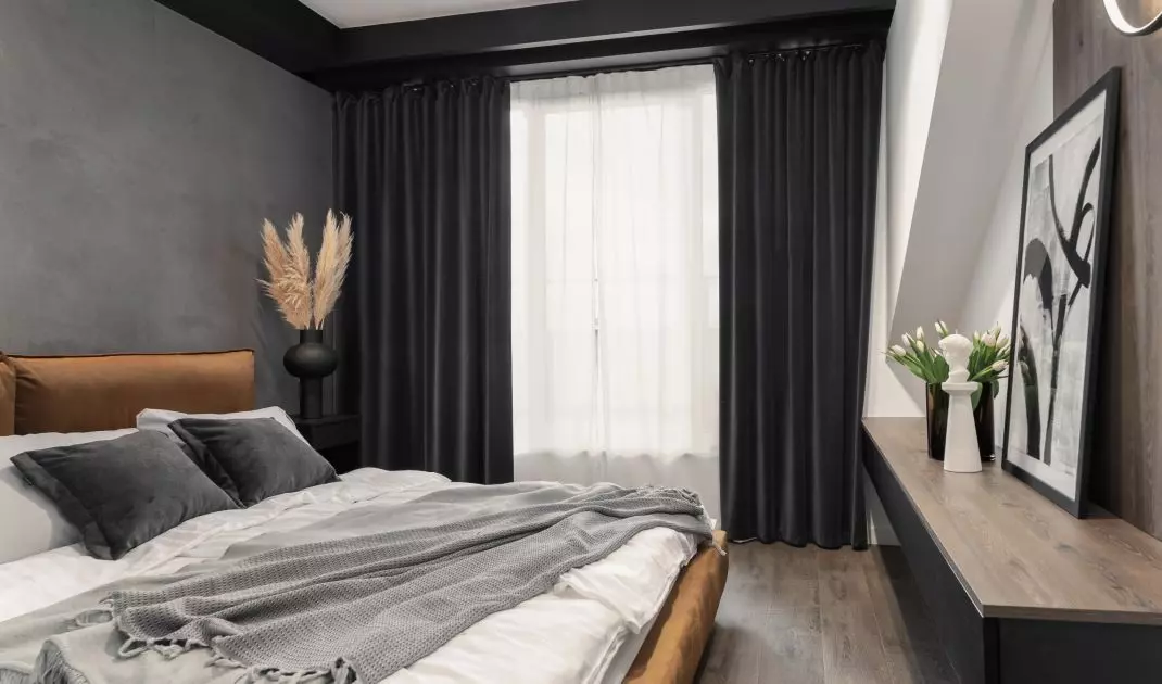 Sypialnia znajduje się na poddaszu. Architektka zastosowała więc grube ciemne zasłony, które chronią przed ostrym światłem