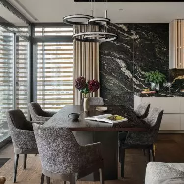 The grain of the table and the upholstery of the chairs refer to the stone used in the kitchen