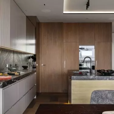 A pantry hides behind the veneered cabinetry