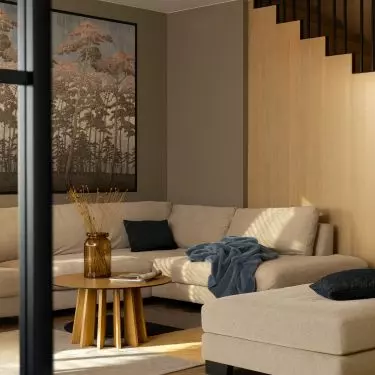 A sliding door with glazed wings in a wooden frame leads to the living room