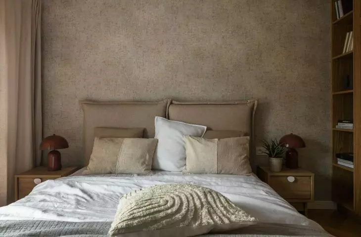 The wall behind the bed was lined with decorative wallpaper