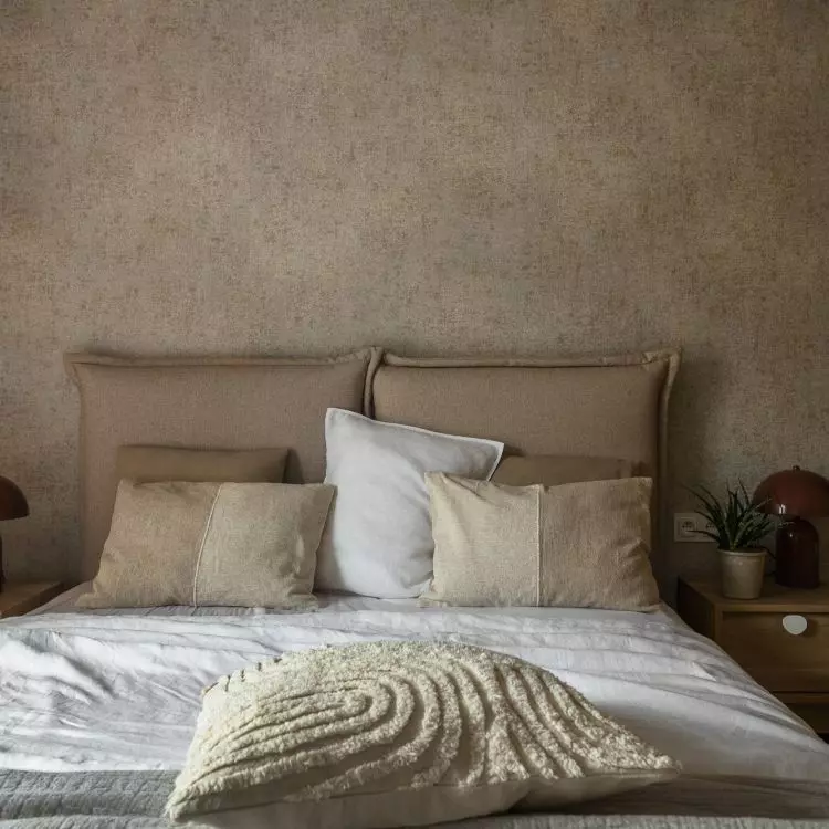 The wall behind the bed was lined with decorative wallpaper