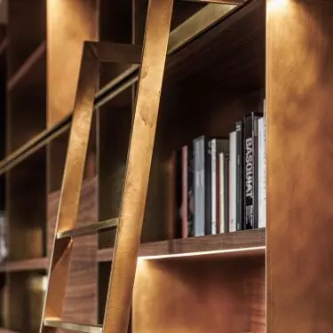 The bookcase was created from walnut wood and brushed brass
