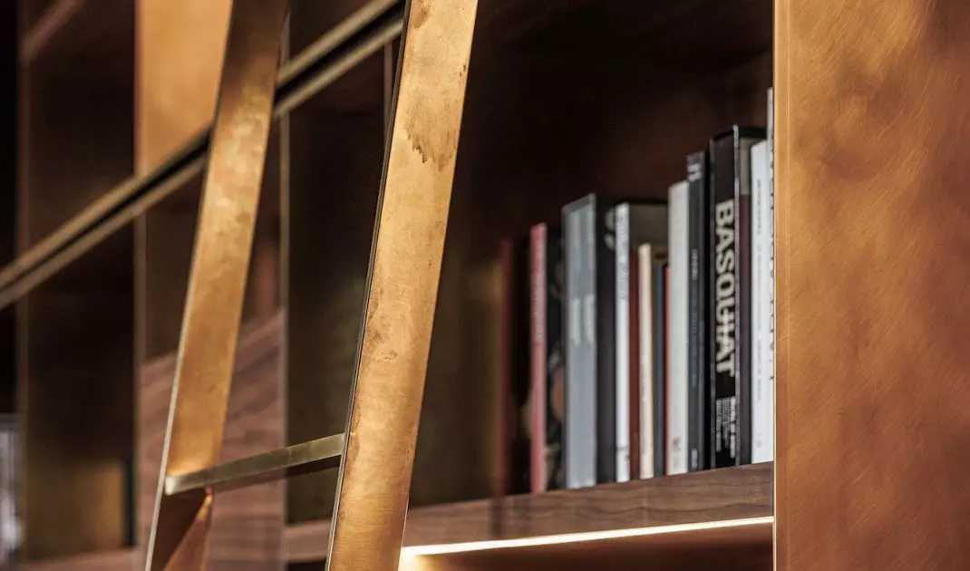 The bookcase was created from walnut wood and brushed brass