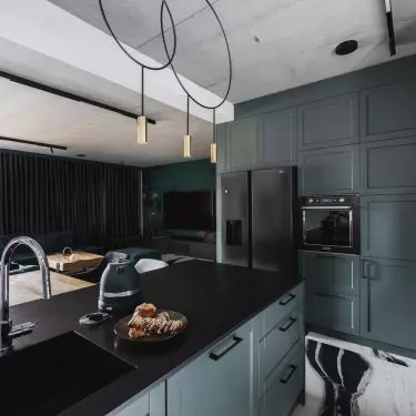 The kitchen is kept in dark colors