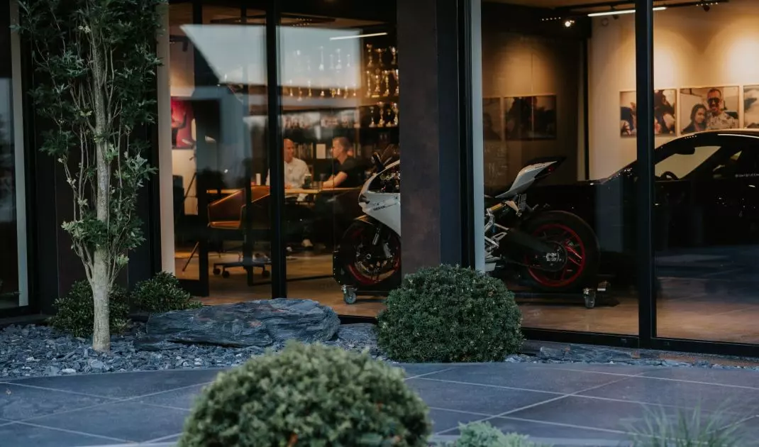 Motorcycles and sports cars were displayed in glass garages