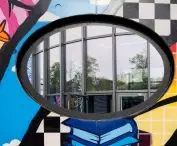 Dziura w murze z graffiti, przez którą można zajrzeć do Pears Judischer Campus