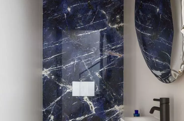 The walls of the guest toilet are covered with blue quartzite