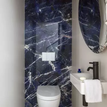 The walls of the guest toilet are covered with blue quartzite