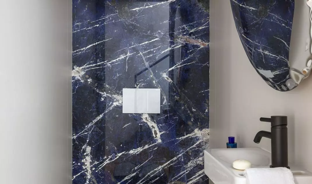 The walls of the guest toilet are covered with blue quartzite