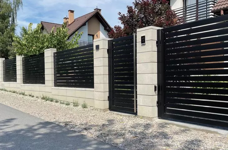 Ogrodzenie murowane z białych bloczków w kompozycji z czarnymi elementami z aluminium