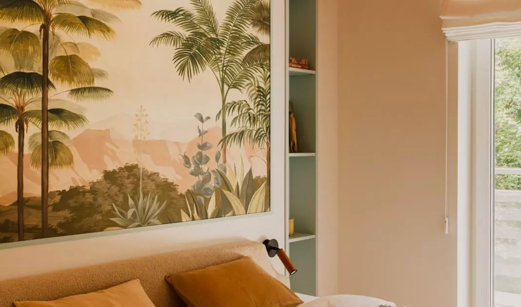 The wall behind the bed is decorated with painterly wallpaper