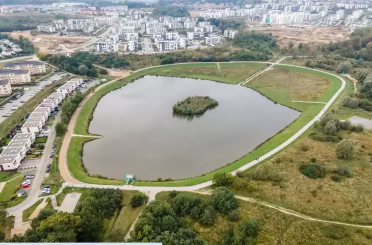 Swietokrzyska reservoir in the Southern Park in Gdansk, Poland. In the background, chaotic buildings 