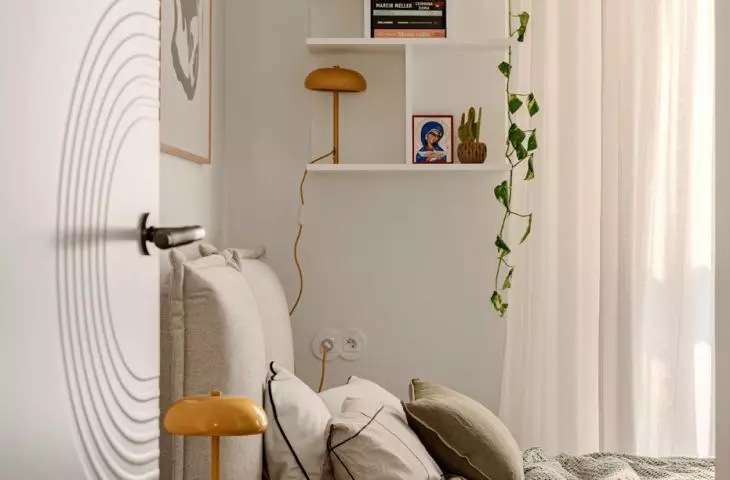 Above the bed there is a bookcase for small items