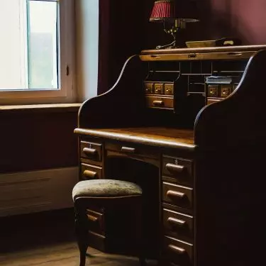 A vintage-style desk can be the centerpiece of a Dark Academia arrangement