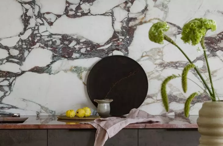 The wall above the countertop is covered with tiles imitating marble