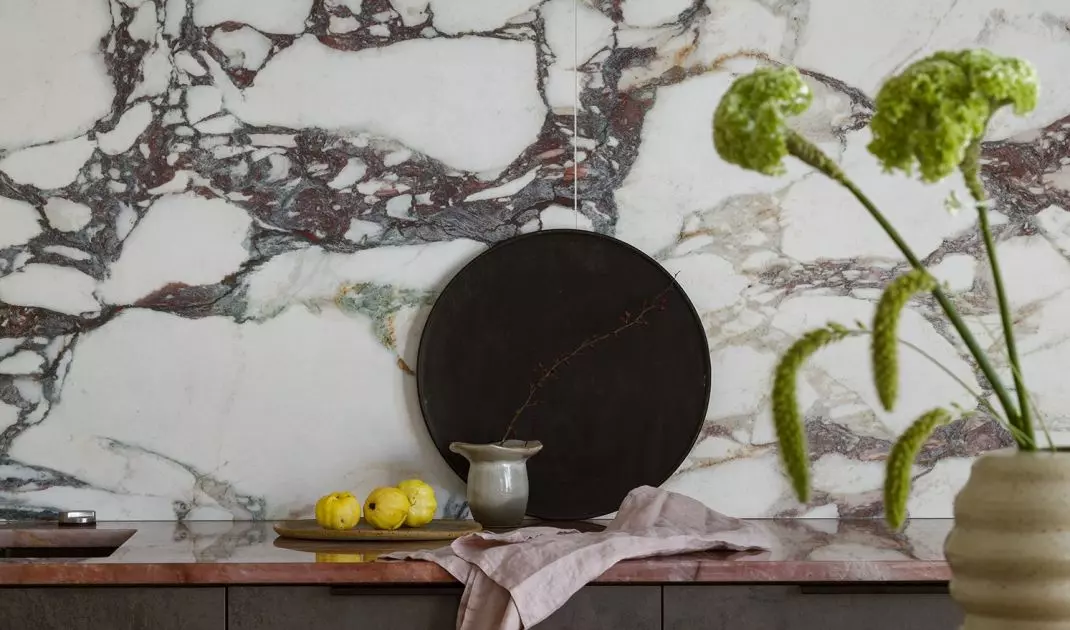 The wall above the countertop is covered with tiles imitating marble