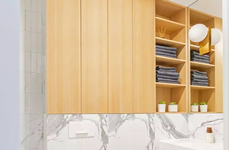 The wooden enclosure above the toilet also has open shelves