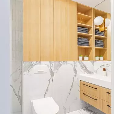 The wooden enclosure above the toilet also has open shelves