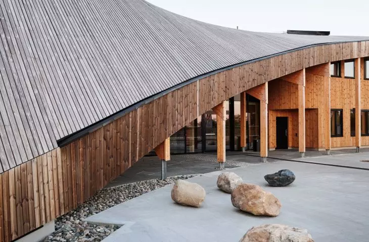 The roof minimizes the visual height of the structure and emphasizes the organic character of the whole body 