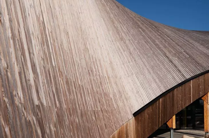 The gabled roof of the building, with an impressive surface area, is covered with wooden boards