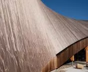The gabled roof of the building, with an impressive surface area, is covered with wooden boards