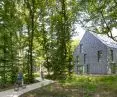 House in the forest with a marked bike path surrounded by greenery and trees