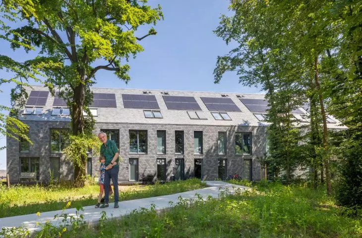Modern house in the forest with solar panels, surrounded by lush vegetation