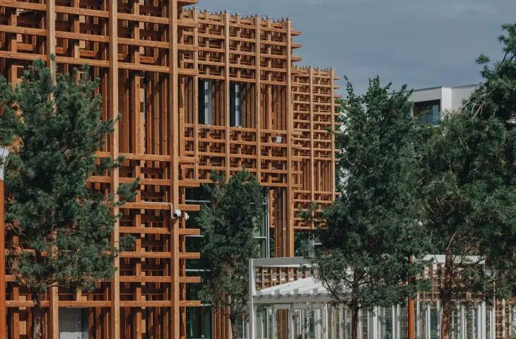 The wooden grille on the facade not only serves an aesthetic function, but also effectively regulates the sunlight, creating a pleasant atmosphere both inside and outside the building